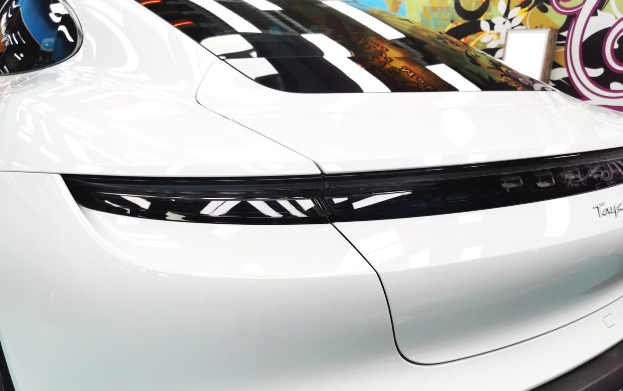 The coated bonnet of the Porsche Taycan under workshop lighting.