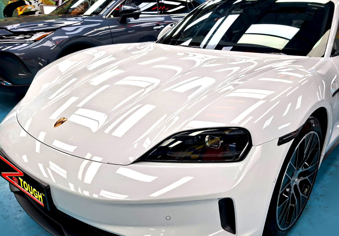 The Porsche Taycan's coated paintwork under workshop lighting.