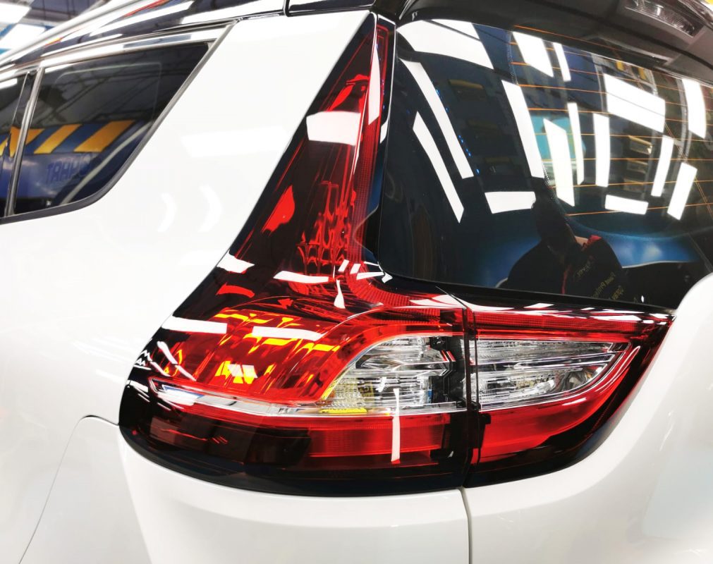 The coated bonnet of the Renault Grand Scenic under workshop lighting.