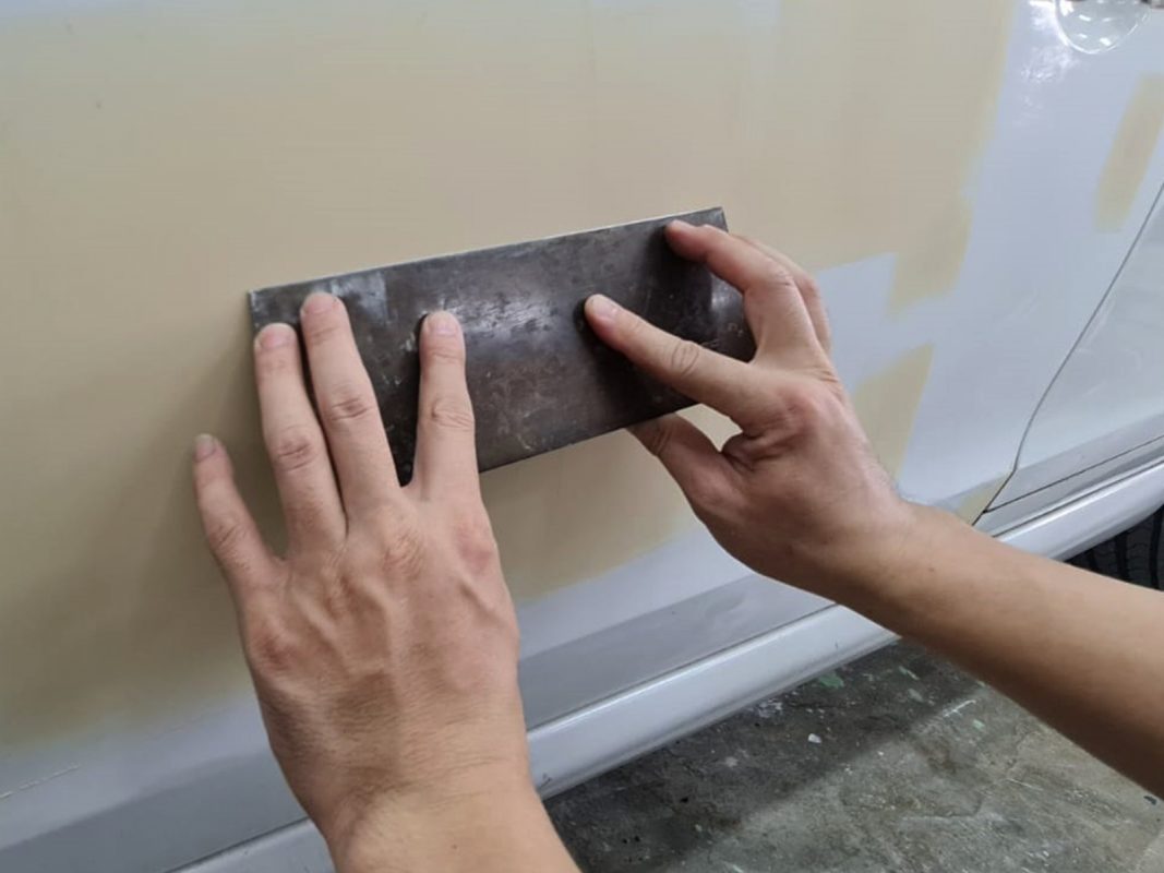 The car's surface inspected and patched where the paintwork was imperfect.