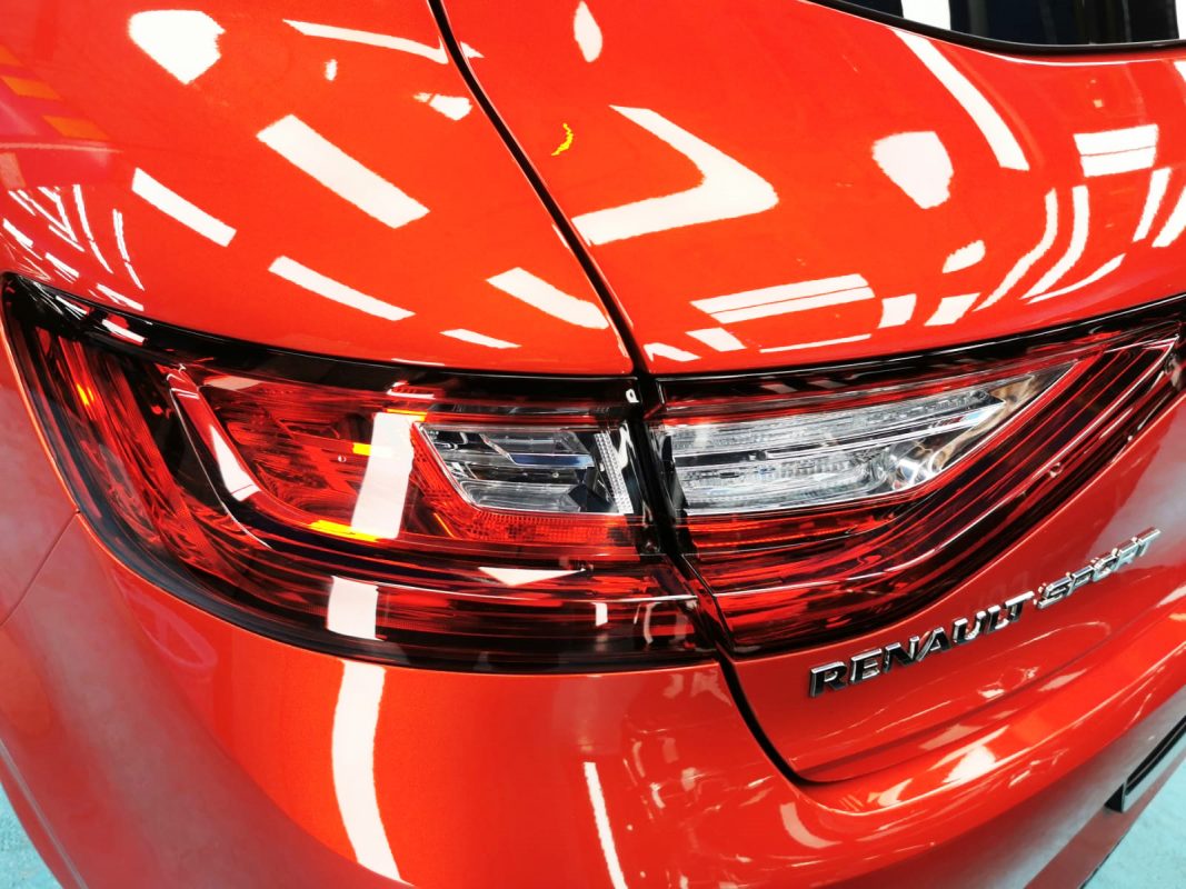 The coated bonnet of the Renault Megane under workshop lighting.