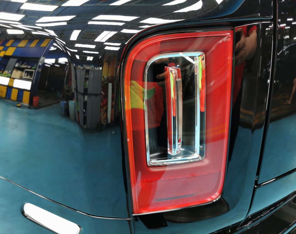 The coated bonnet of the Rolls-Royce Cullinan under workshop lighting.