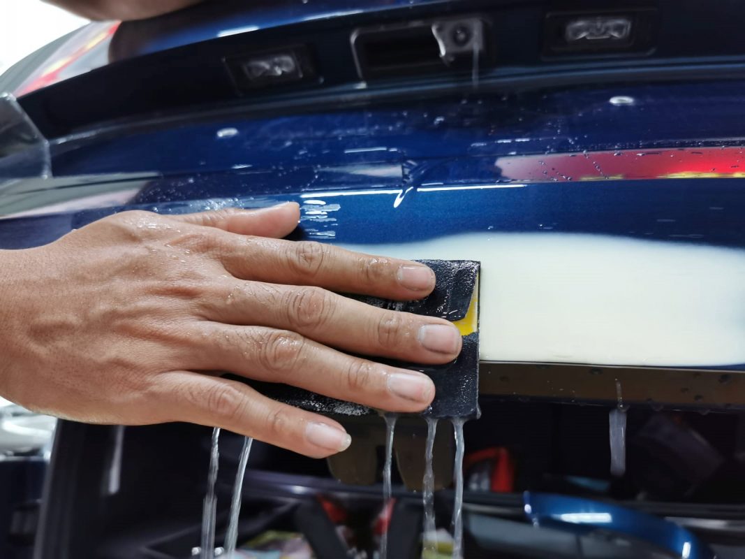 Wet-sanding the Kodiaq's panels to smooth the existing paintwork.
