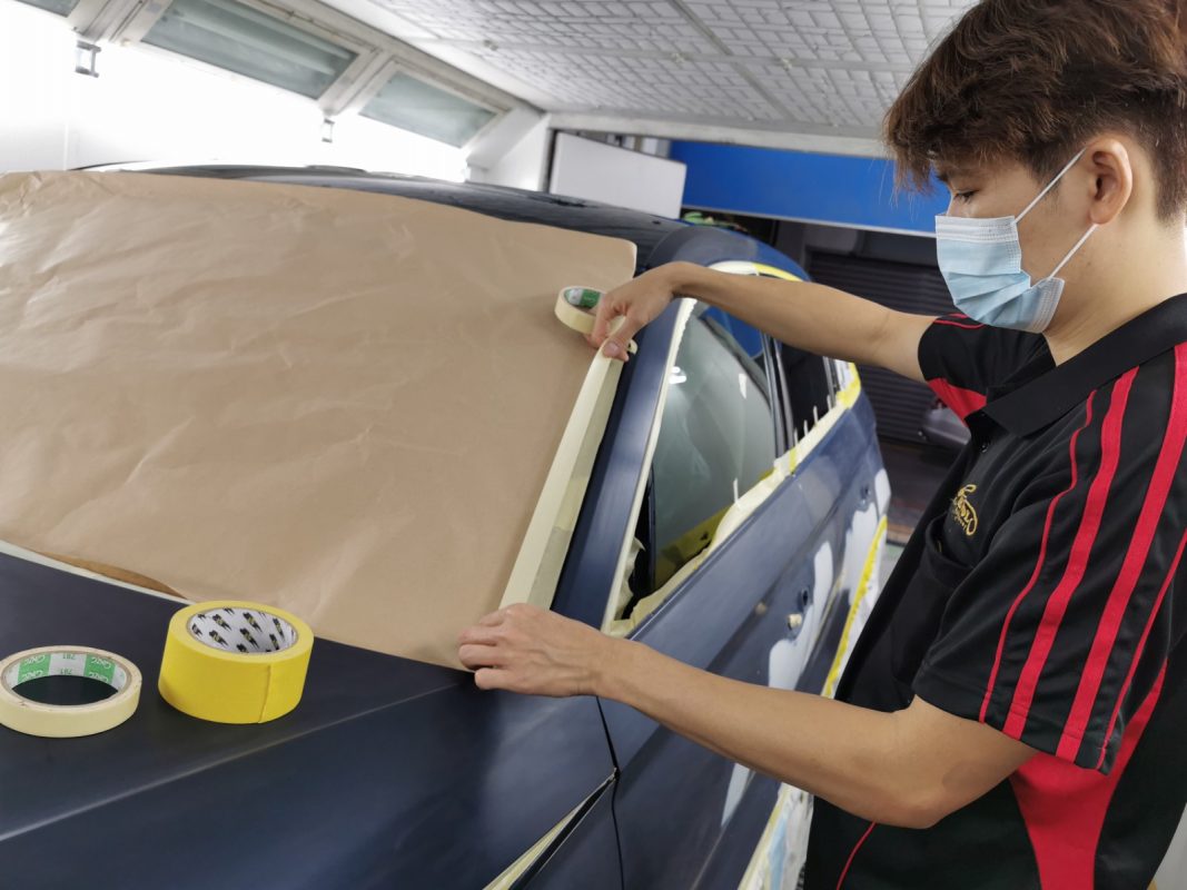 Non-painted surfaces being masked off on the Kodiaq before spraying.