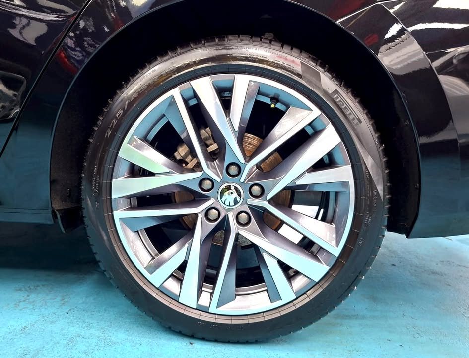 Silver multi-spoke alloy wheel on the black Skoda Octavia.