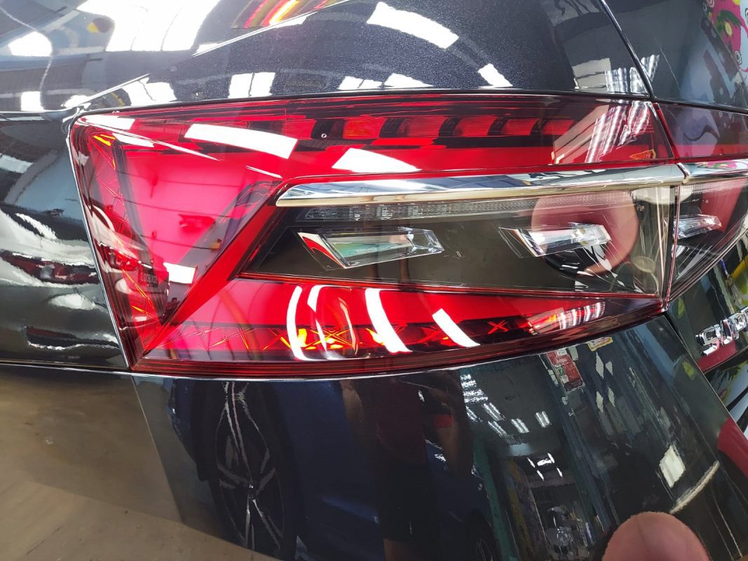 The coated bonnet of the Skoda Superb under workshop lighting.