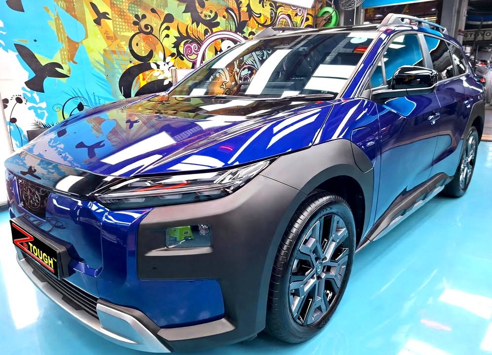 Front three-quarter view of a blue Subaru E-Outback with black wheel arch cladding in the Revol Carz Makeover studio, ZeTough plate on the bumper.