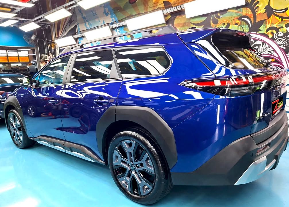 Rear three-quarter view of the blue Subaru E-Outback showing the tail lights and roof rails.