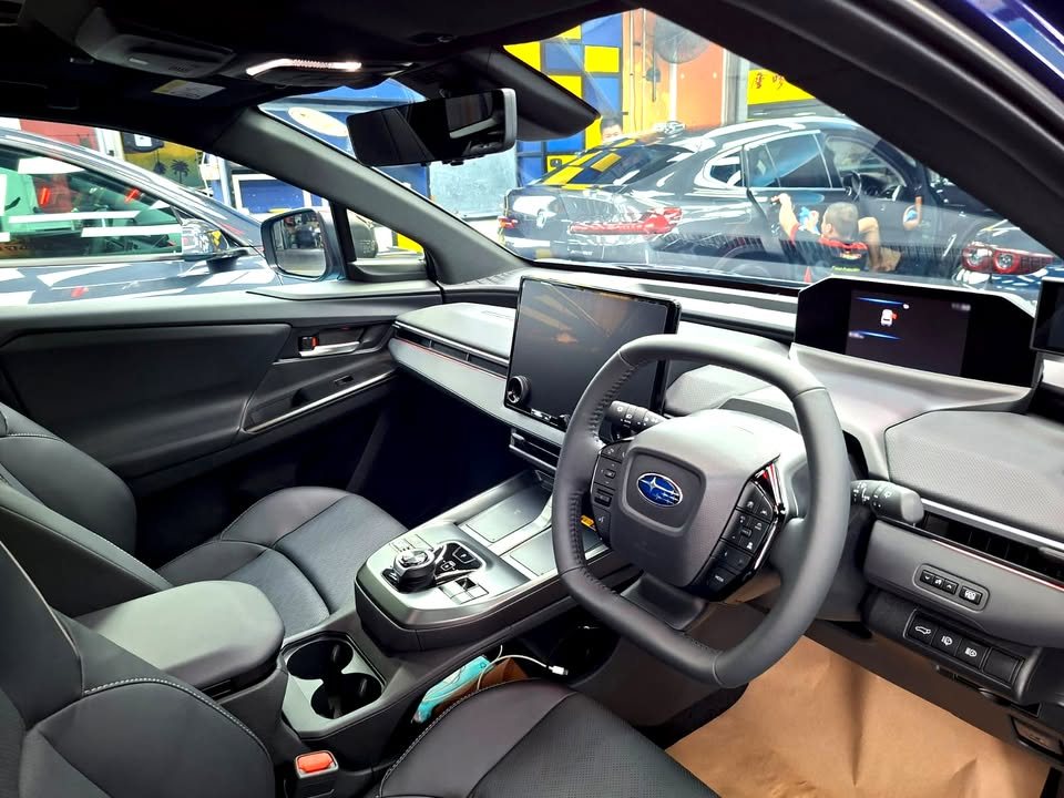 Interior of the Subaru E-Outback with black seats, steering wheel and centre touchscreen.