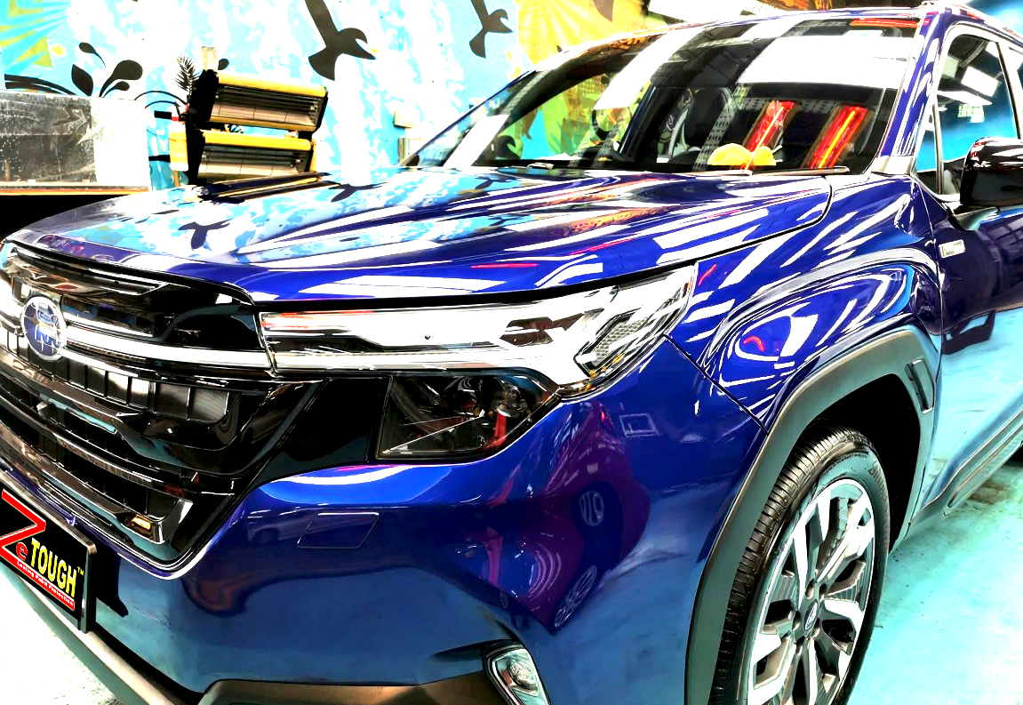 The Subaru Forester's coated paintwork under workshop lighting.