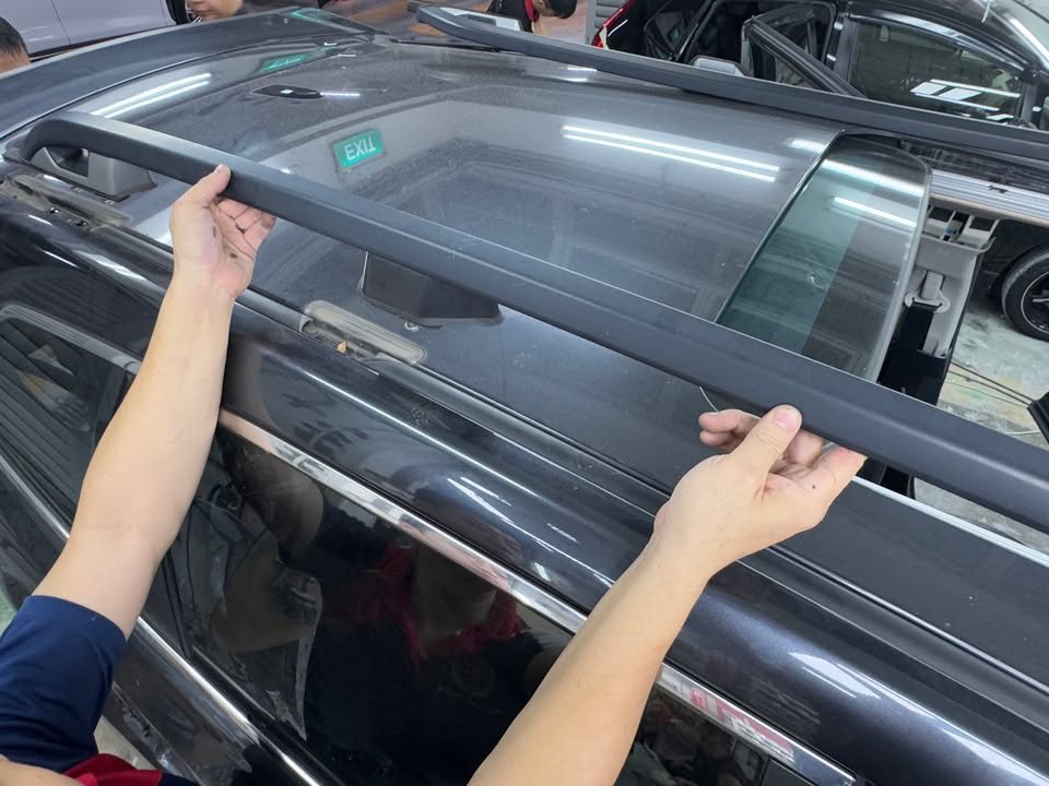 Technician lifting the roof rail trim off the Forester.