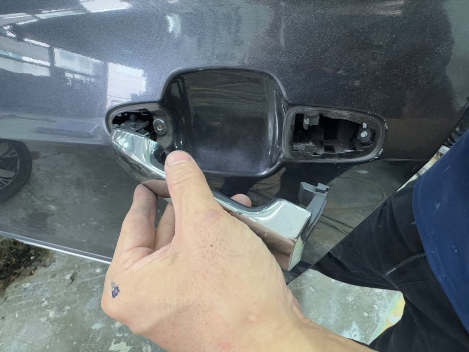 Door handle being removed from the Forester's door.
