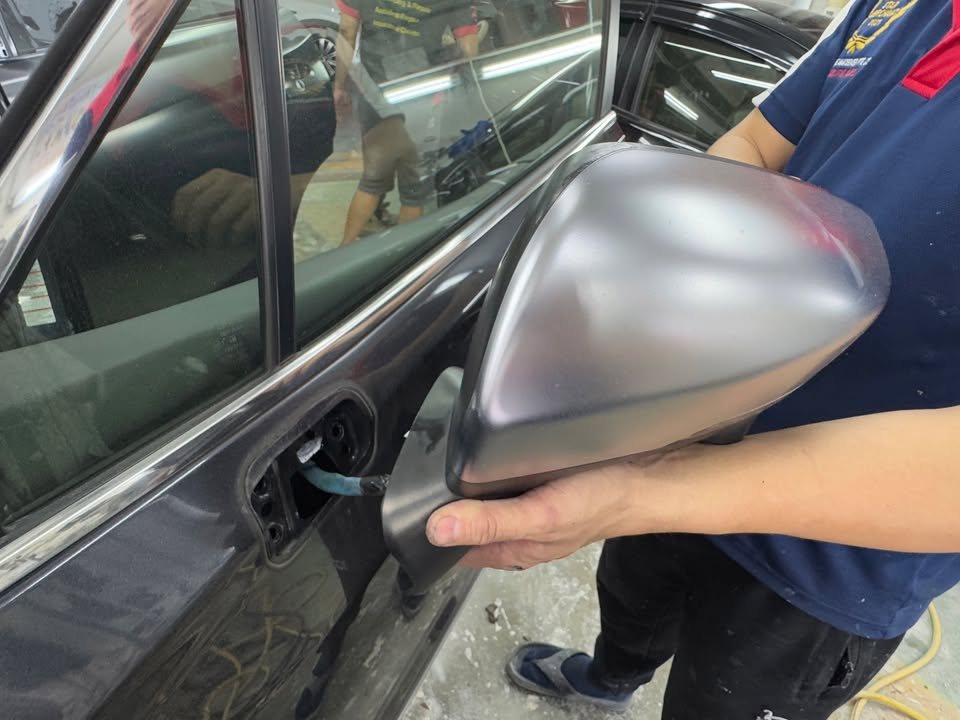 Side mirror cover being refitted on the Forester.
