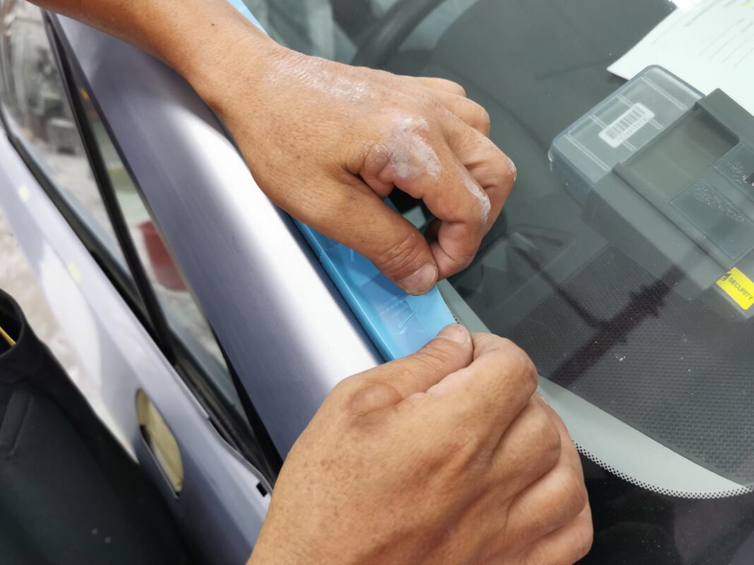 Non-painted surfaces being masked off on the Forester before spraying.