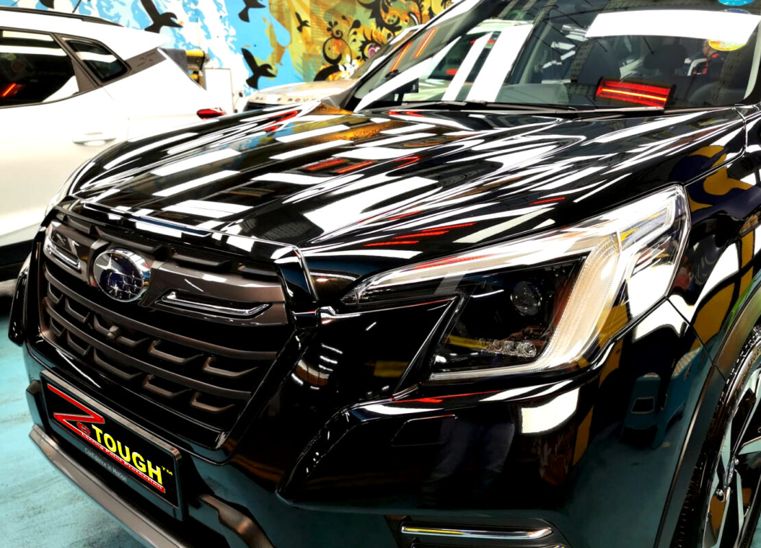 The black Subaru Forester from a side angle after the ceramic coating.
