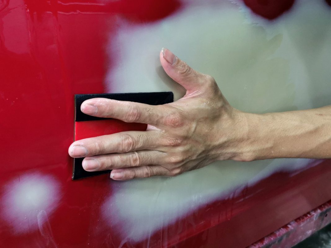 Wet-sanding the whole surface of the Impreza for an even finish.