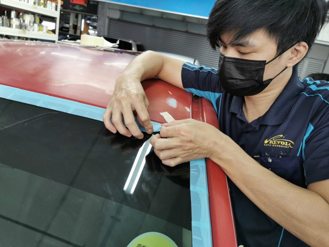 Non-painted surfaces being masked off on the Impreza before spraying.