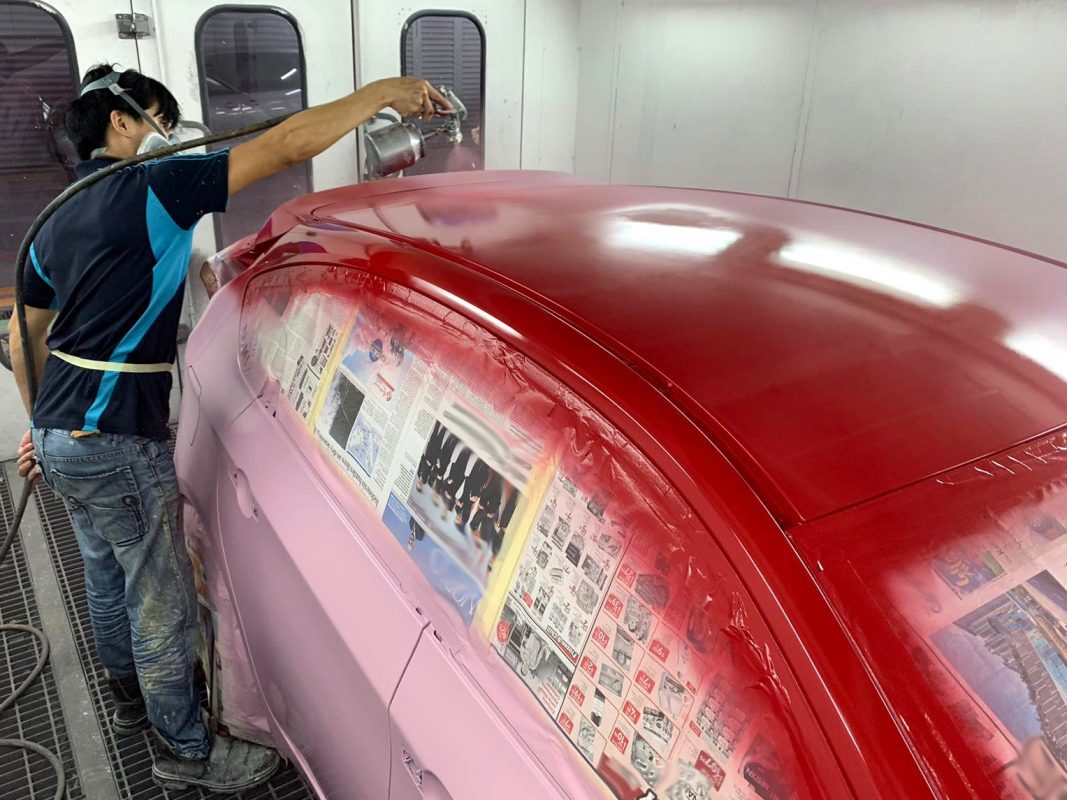 The Impreza being sanded after spraying to remove minute impurities.