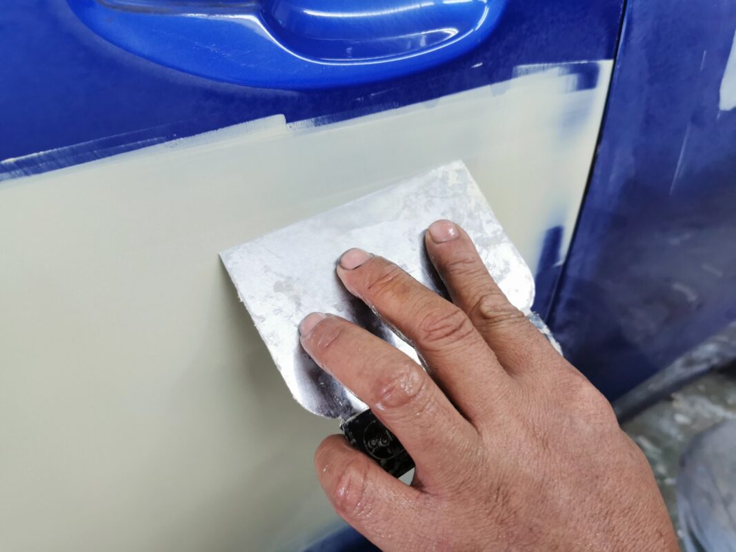 Damaged areas being patched and smoothed on the Subaru WRX.