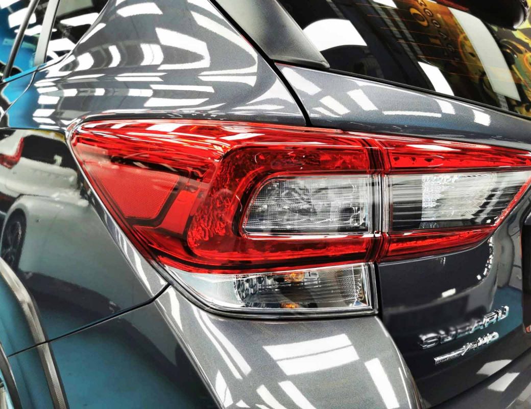 The coated bonnet of the Subaru XV under workshop lighting.