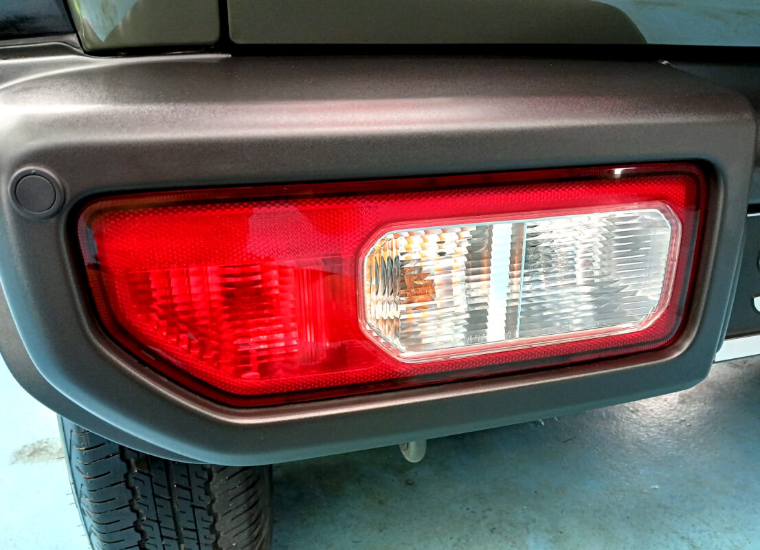 The coated bonnet of the Suzuki Jimny under workshop lighting.