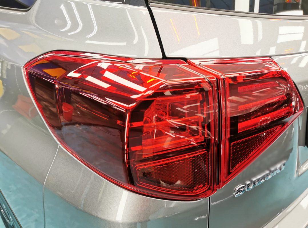 The coated bonnet of the Suzuki Vitara under workshop lighting.