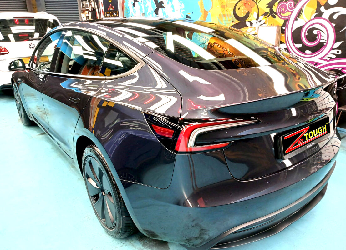 Rear quarter of the Tesla Model 3, glossy and protected.
