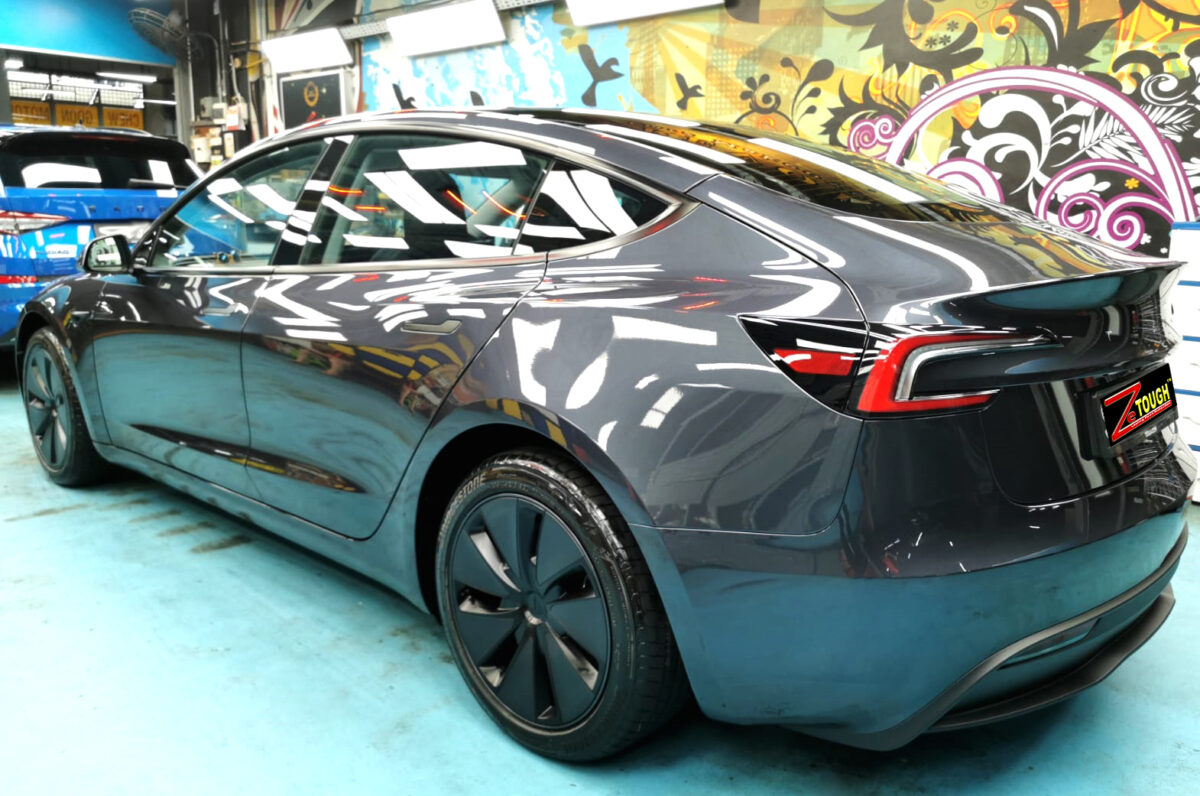 Rear quarter of the Tesla Model 3, glossy and protected.
