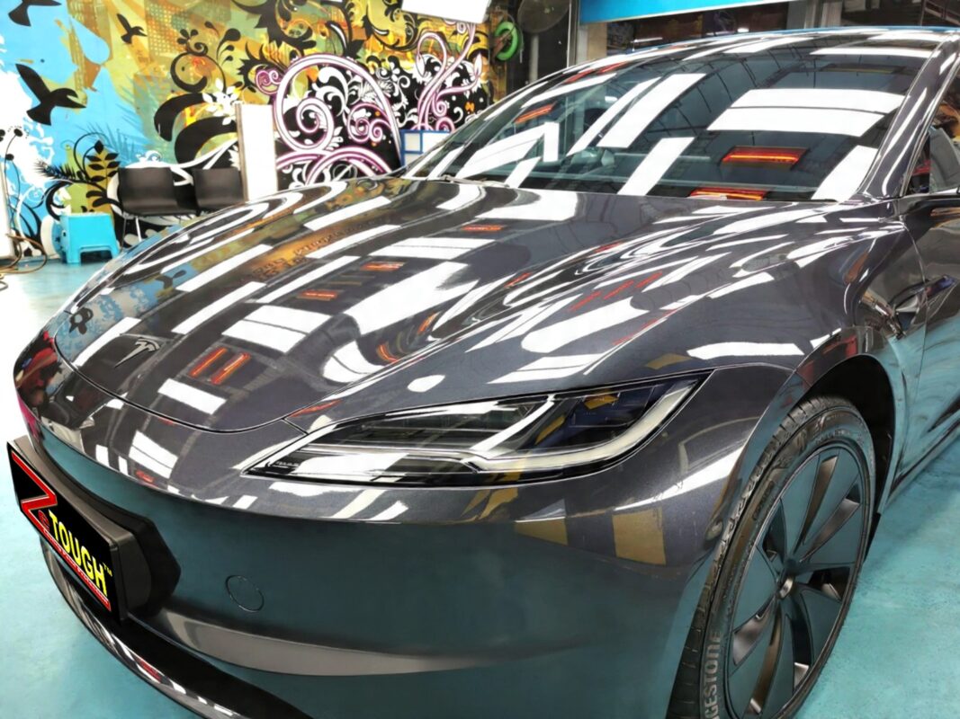 The Tesla Model 3's coated paintwork under workshop lighting.