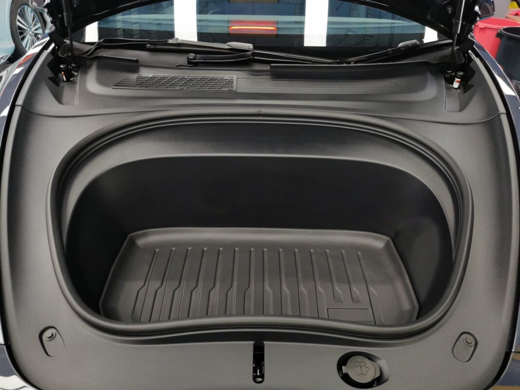 Reflections across the coated panels of the Tesla Model 3.