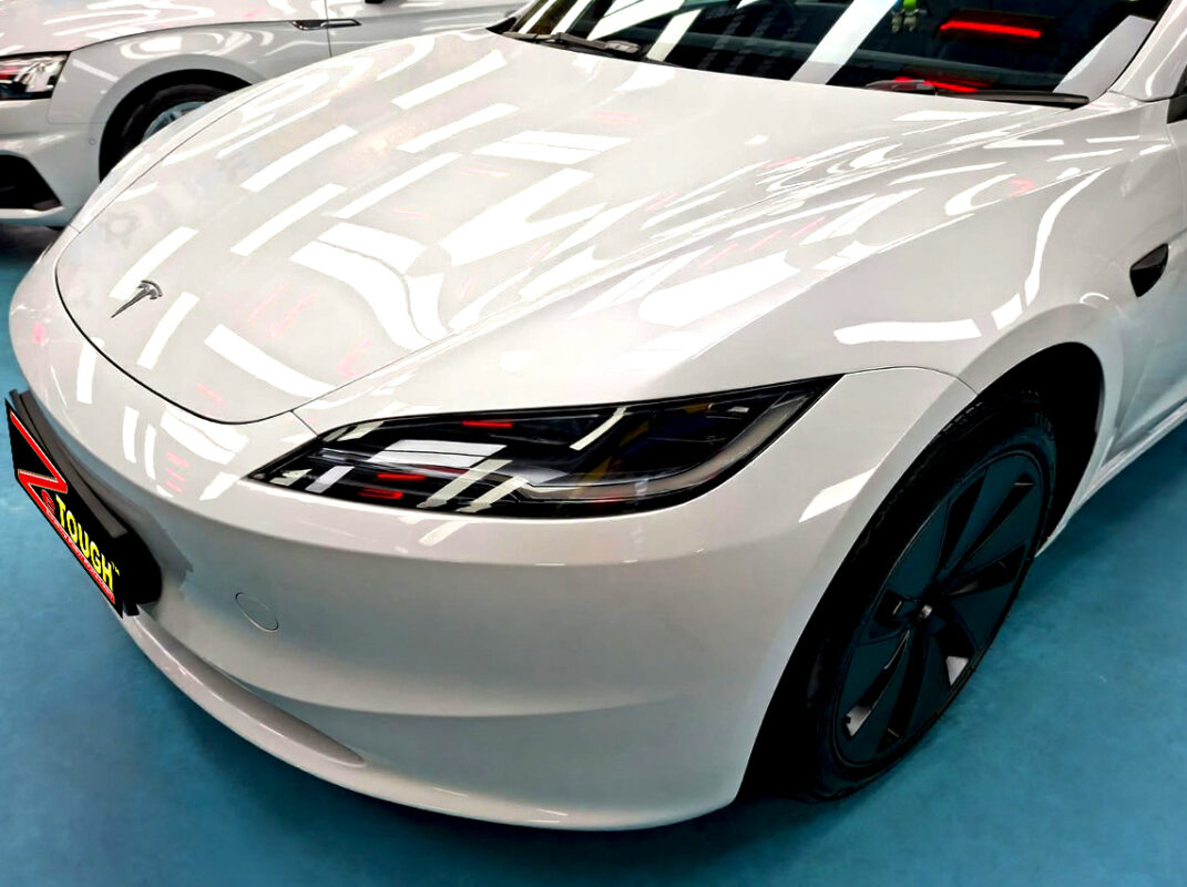 The Tesla Model 3's coated paintwork under workshop lighting.