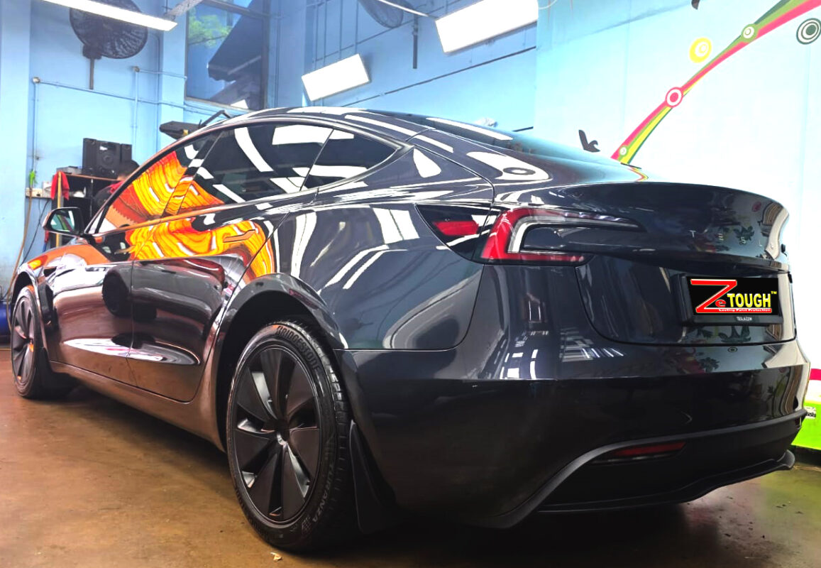 Rear quarter of the Tesla Model 3, glossy and protected.