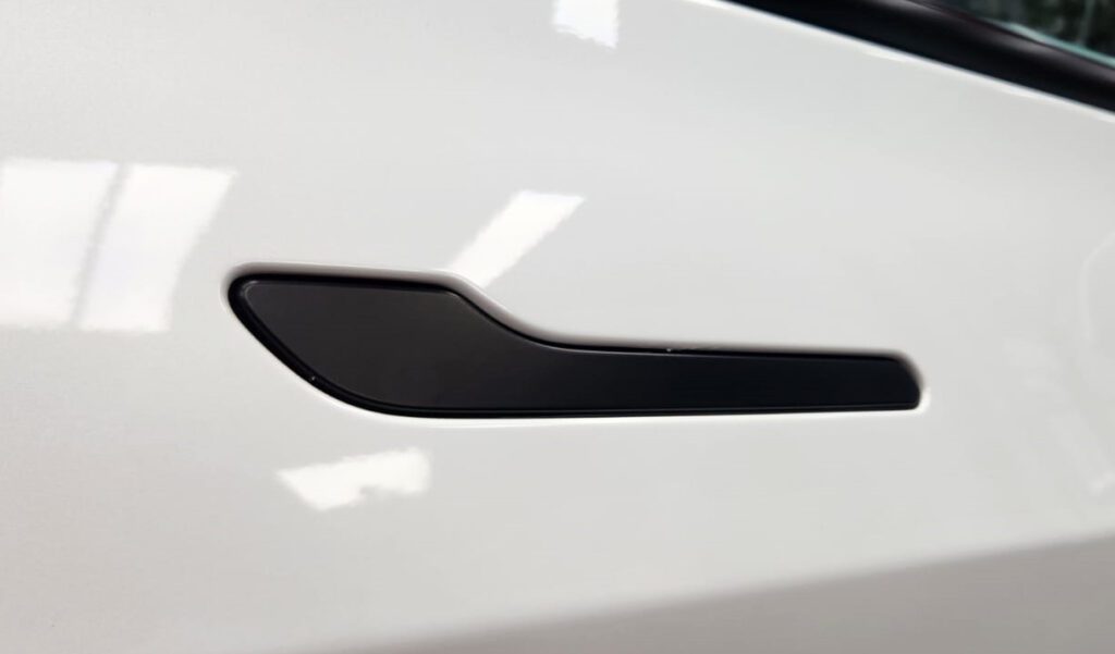 The Tesla Model 3 parked in the workshop, freshly coated.