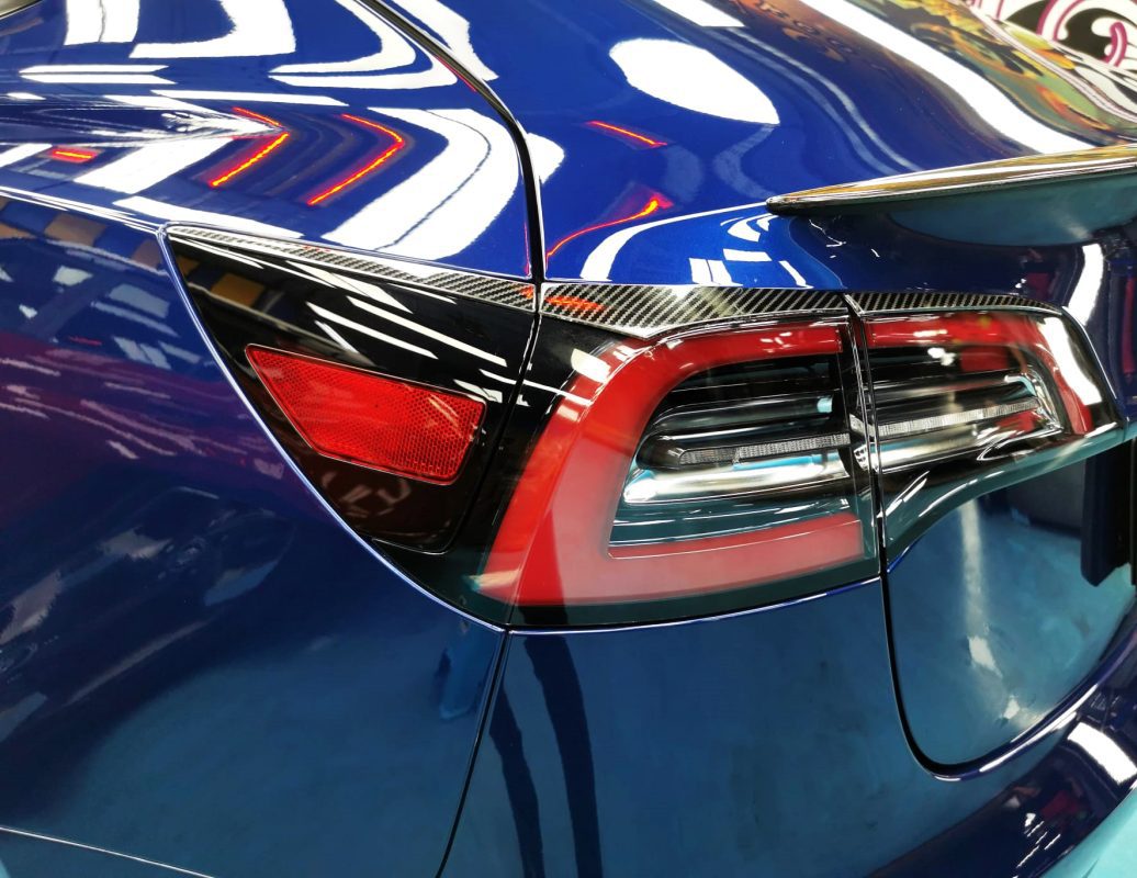 Rear quarter of the Tesla Model 3, glossy and protected.