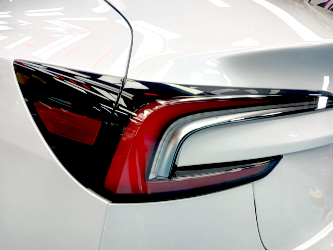 Rear quarter of the Tesla Model 3, glossy and protected.
