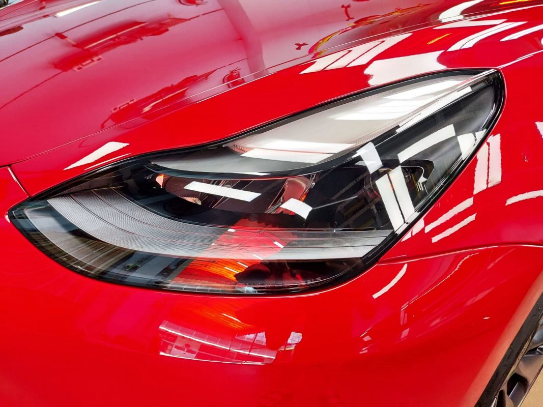 The Model 3's red coated paintwork showing clean reflections.