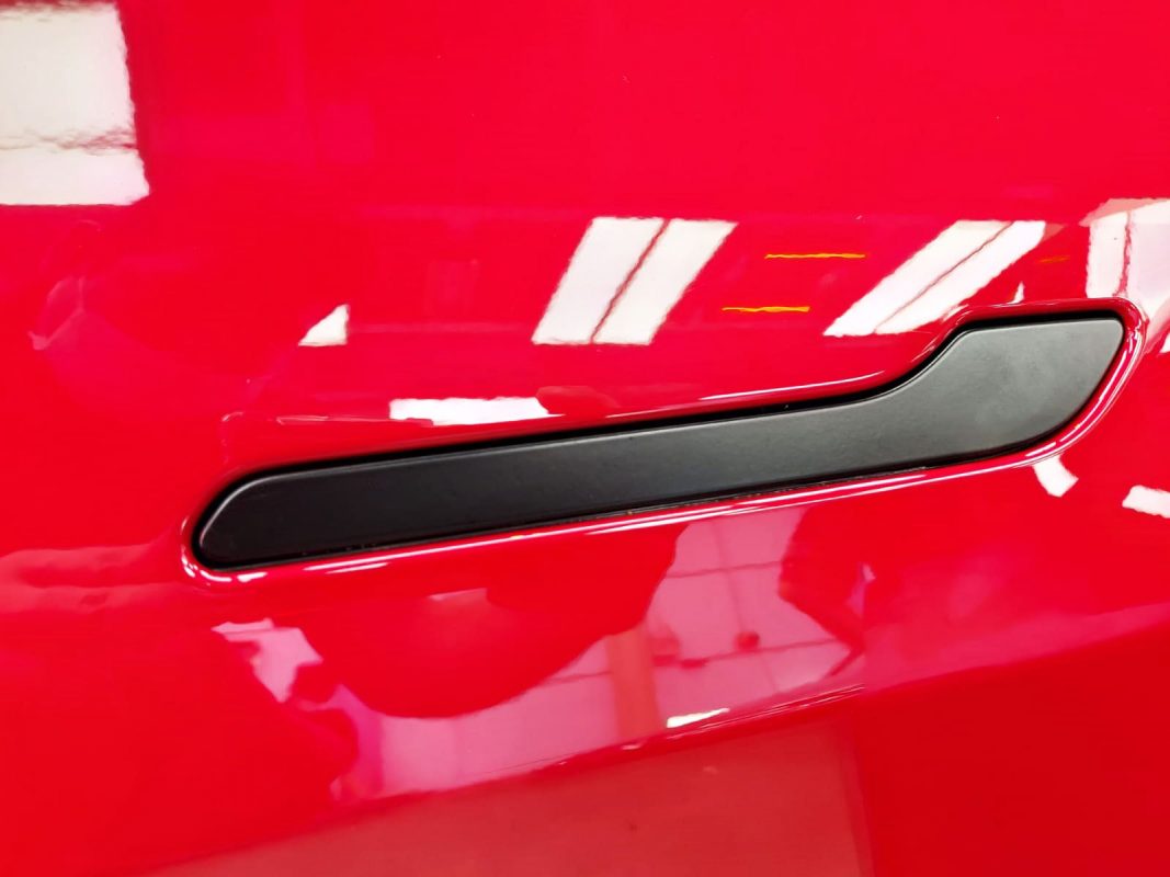 Front three-quarter view of the red Tesla Model 3 after coating.