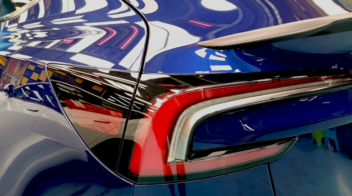 Rear quarter of the Tesla Model 3, glossy and protected.