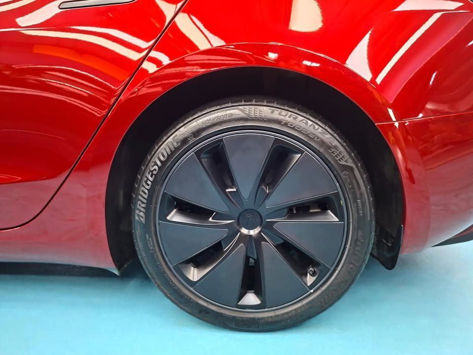 Rear wheel with black aero cover under the red wheel arch.