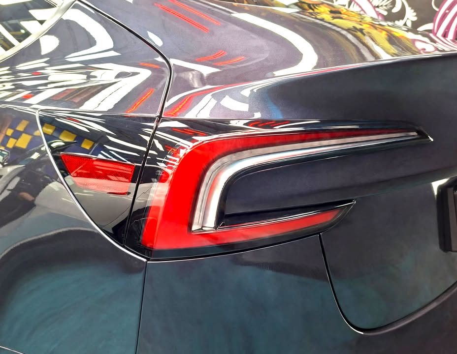 Rear tail lamp and quarter panel of the Tesla Model 3.