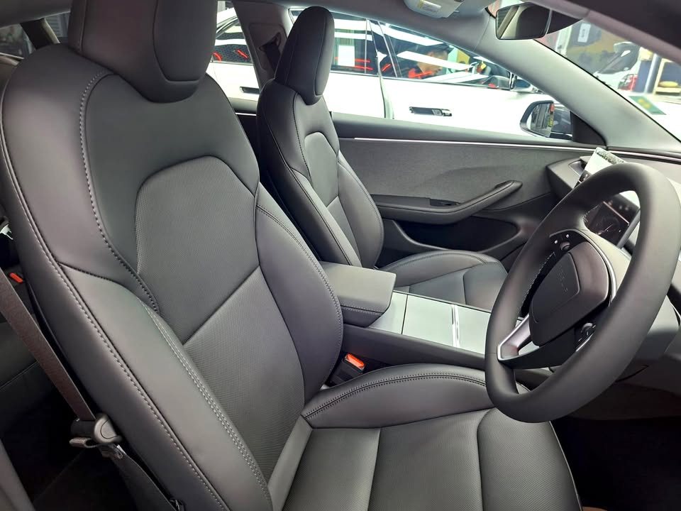 Front seats and steering wheel of the Tesla's black interior.