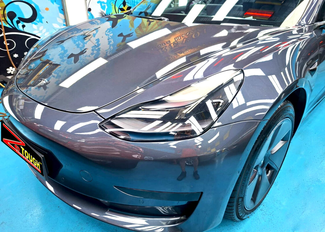 The Tesla Model 3's coated paintwork under workshop lighting.