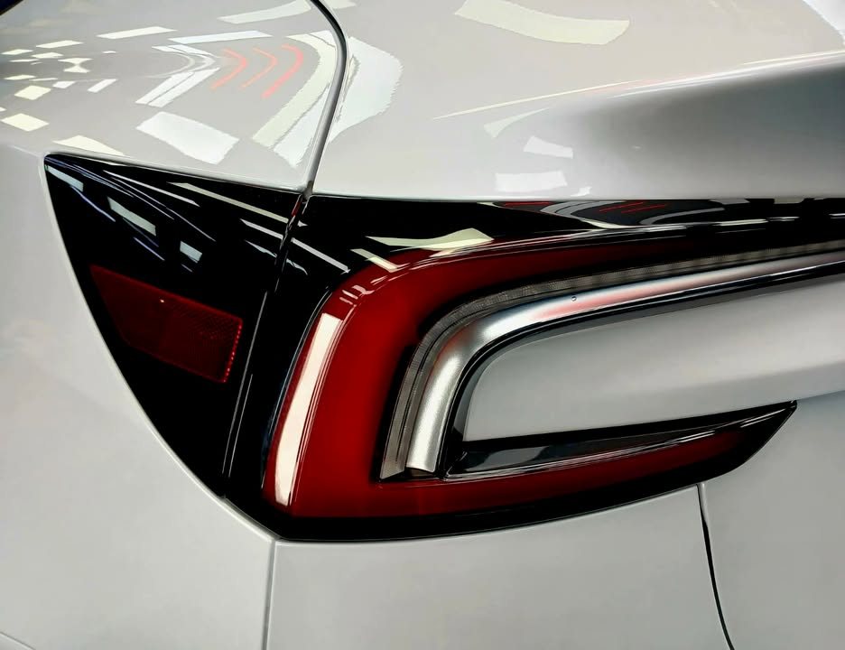 Close-up of the red tail lamp on the white rear quarter.