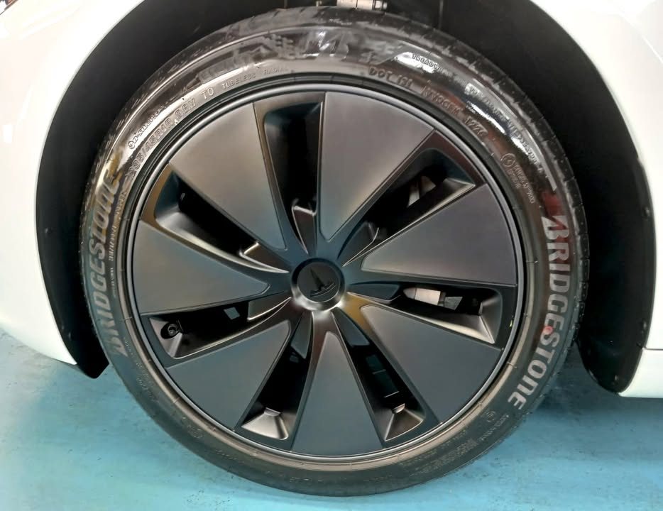 Wheel with a dark grey aero cover and Bridgestone tyre.