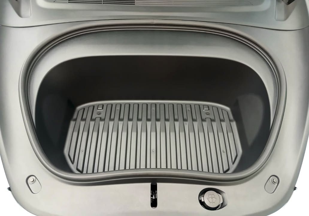 The front storage compartment with a ribbed grey mat.
