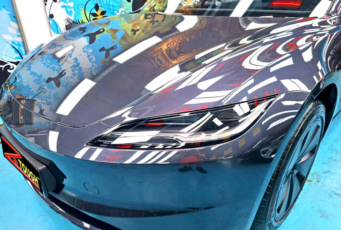The Tesla Model 3's coated paintwork under workshop lighting.