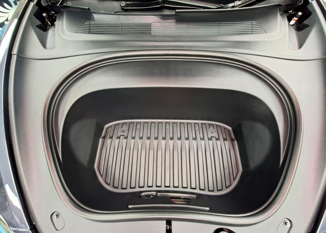 Reflections across the coated panels of the Tesla Model 3.