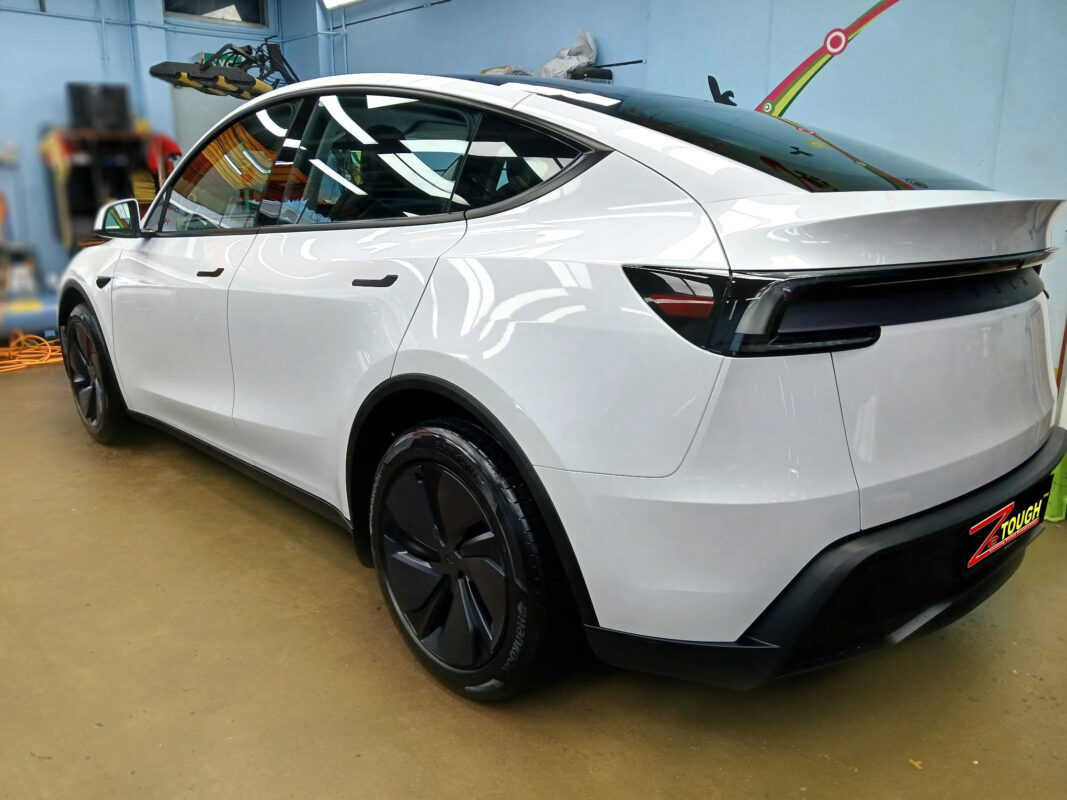 Rear quarter of the Tesla Model Y, glossy and protected.