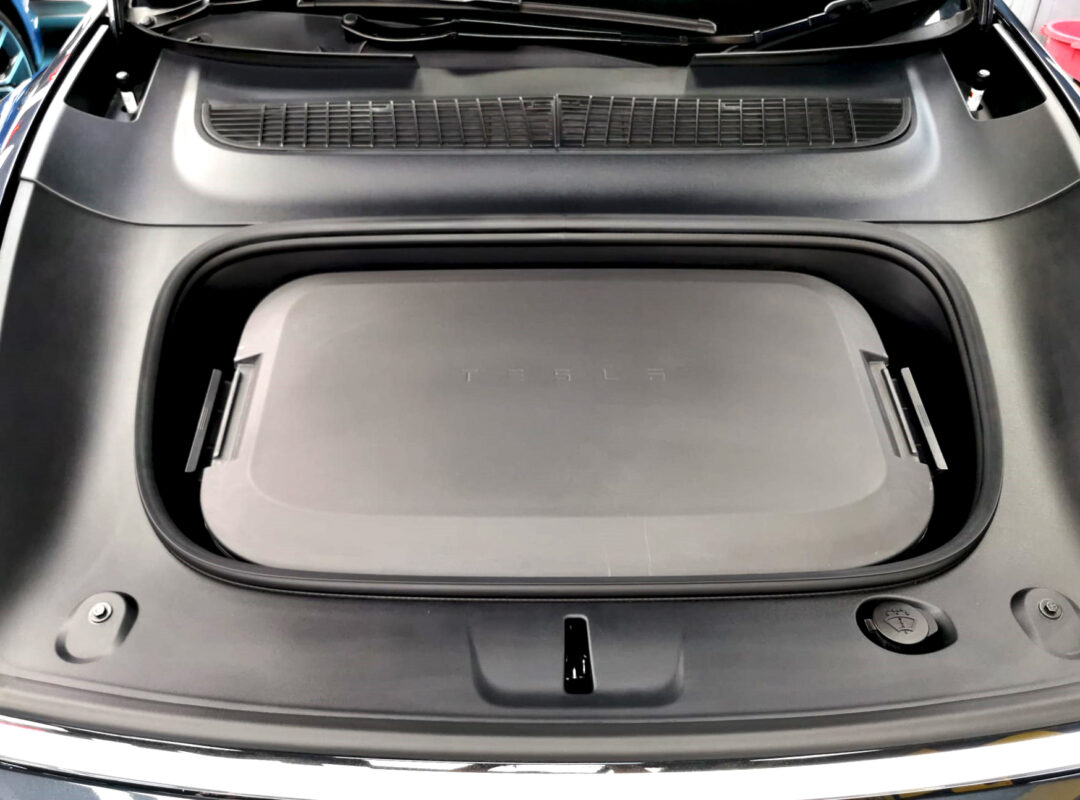 Reflections across the coated panels of the Tesla Model Y.