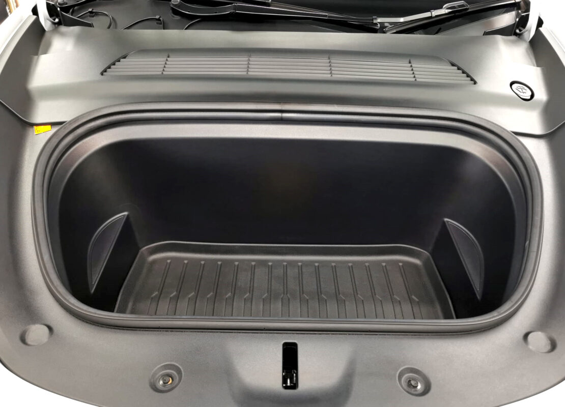 Reflections across the coated panels of the Tesla Model Y.